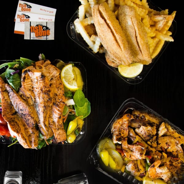 Three Fish Bone seafood meals: fried fish with fries, grilled fish with salad, and grilled shrimp with peppers.